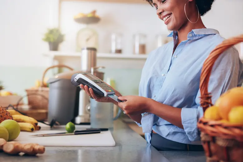 A working woman inserting a credit card into a portable credit card reader.