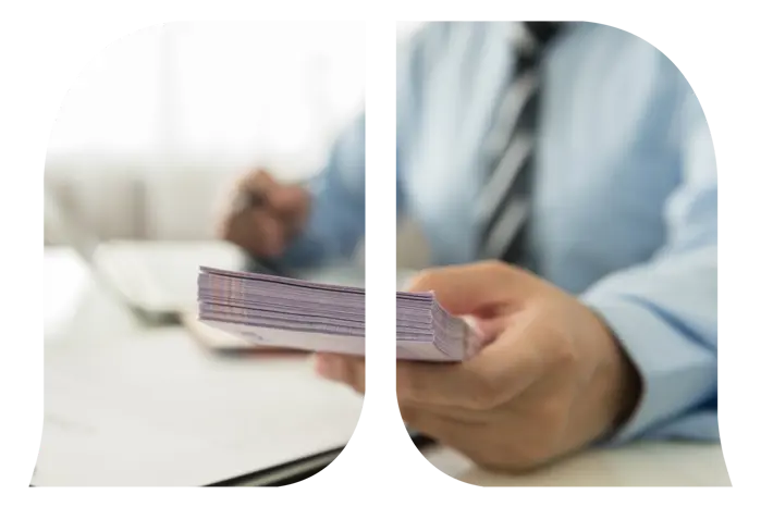 Man's hand holding a stash of paper bills.