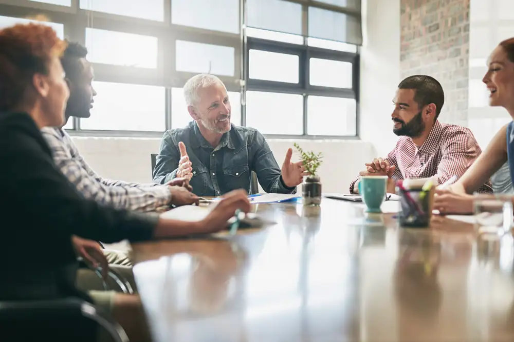 Group of co-workers having a discussion around a table.