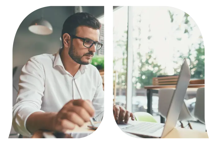 A man working on his laptop while holding a pen.