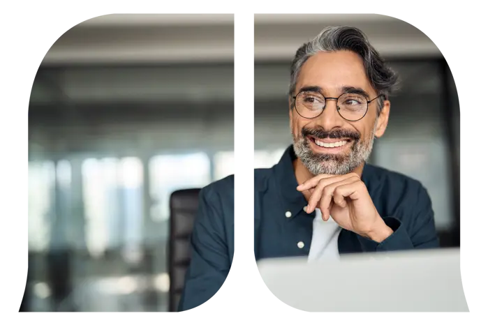 A man smiling while using his laptop.