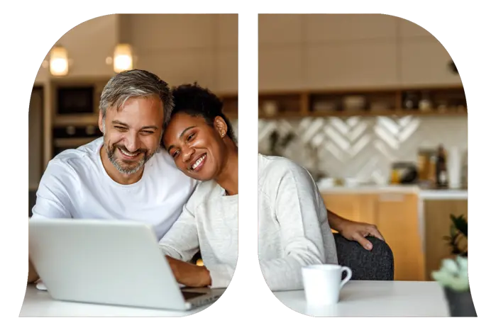 A woman leaning on a shoulder of a man as they are both looking at a laptop.
