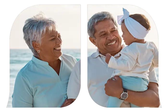 Grandparents holding their granddaughter at the beach.