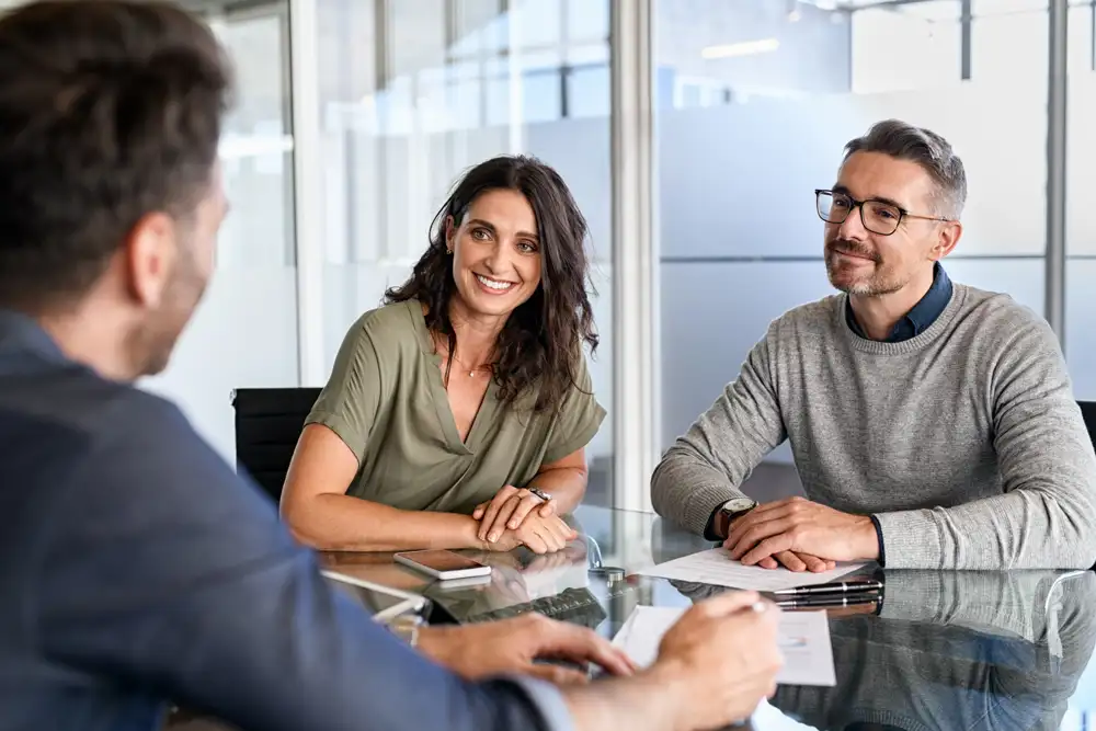 A man and woman talking to an advisor in a room.