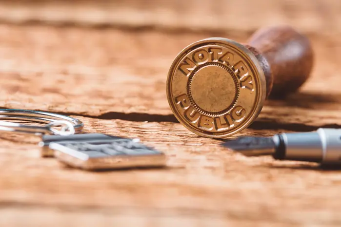 A stamp that says "Notary Public" laying on a table.